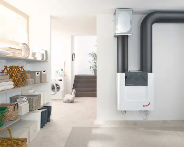 Sistema de ventilación con recuperación de calor Zehnder ComfoAir Q, con tuberías grises y un diseño blanco moderno.