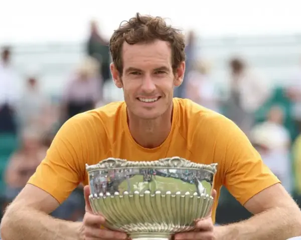Andy Murray sonríe con un trofeo plateado, un reflejo de su impresionante palmarés.