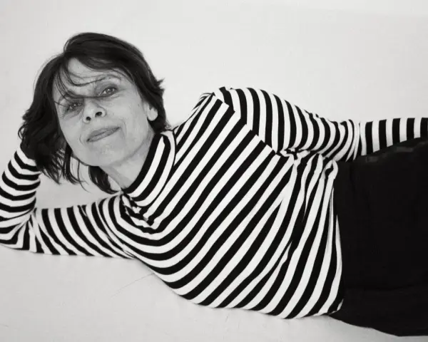 Katarzyna Krzanowska w czarno-białym swetrze w paski, leżąca na boku, z ręką pod głową.
