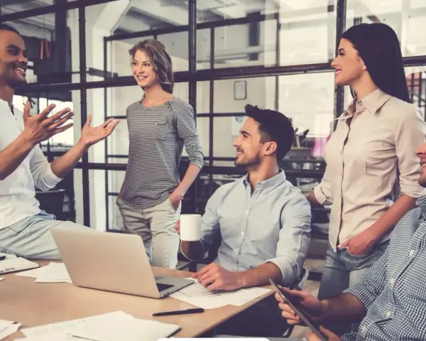 Un gruppo di persone in un ufficio moderno discute animatamente. I colleghi non sono amici, ma lavorano insieme con professionalità.