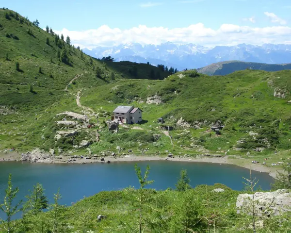 Sentiero per il lago di Erdemolo, con rifugio e montagne sullo sfondo.