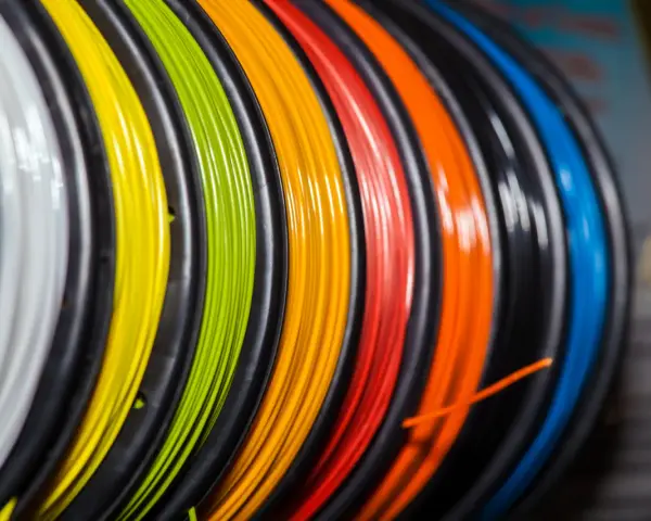 Kolorowy filament do druku 3D, nawinięty na szpulki. Zastanawiasz się, filament co to? To materiał do tworzenia trójwymiarowych obiektów.