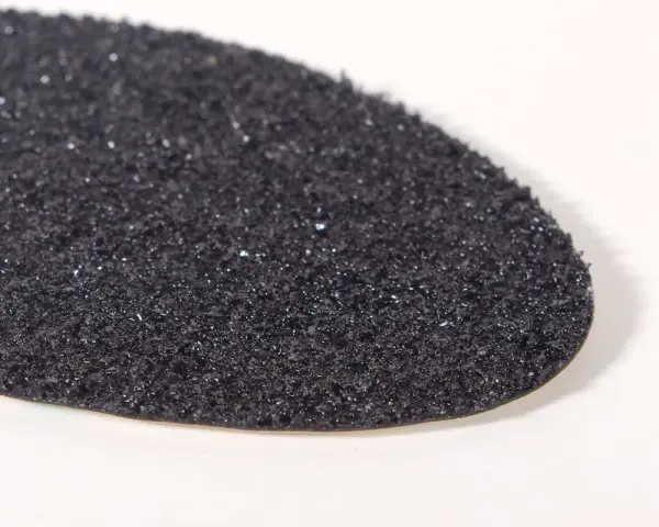 Textura granulada de una suela de caucho resbala, con pequeños brillos que capturan la luz.