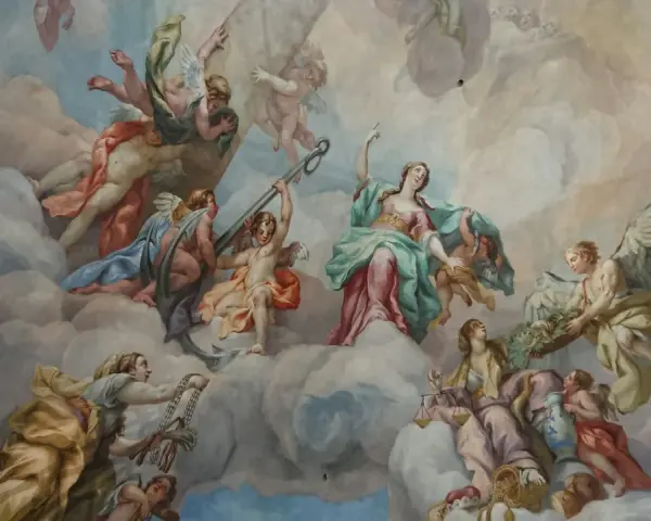 Deckenmalerei mit vielen geflügelten Figuren, die durch Wolken schweben. Eine Frau mit Waage wirkt wie ein engel auf erden.