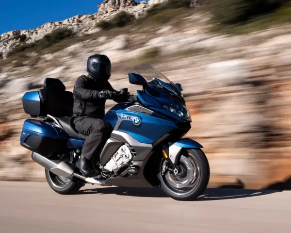Motocyklista w kasku przemierza malowniczą trasę, odkrywając różne rodzaje turystyki.