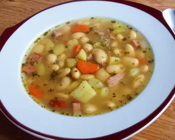 Aksamitna zupa fasolowa przepis babci, pełna białej fasoli, ziemniaków, marchewki i kawałków wędzonki. Aromatyczna i sycąca.