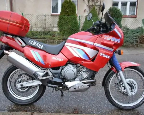 Czerwony motocykl Yamaha XTZ 750 Super Tenere, gotowy na przygodę. Dane techniczne tego modelu są imponujące.