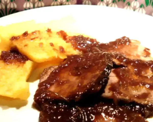 Stracotto al Chianti succulento su un letto di polenta dorata. Un piatto che profuma di tradizione e sapori intensi.