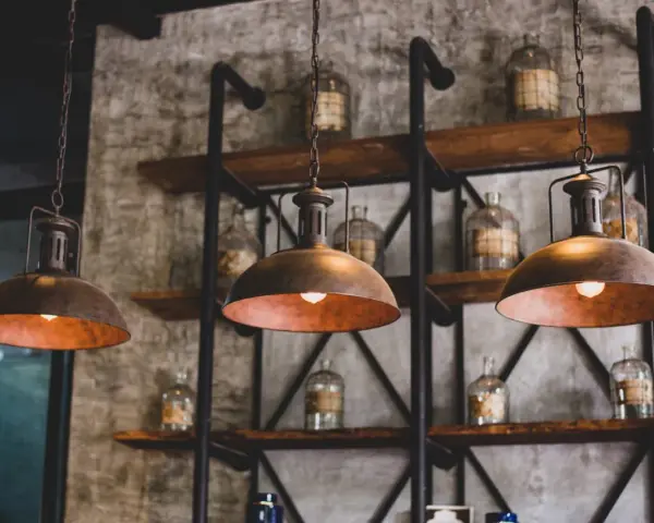 Industrialne lampy wiszące nad półkami ze słoikami. Dowiedz się, jak wyczyścić abażur z lampy, by odzyskał dawny blask.