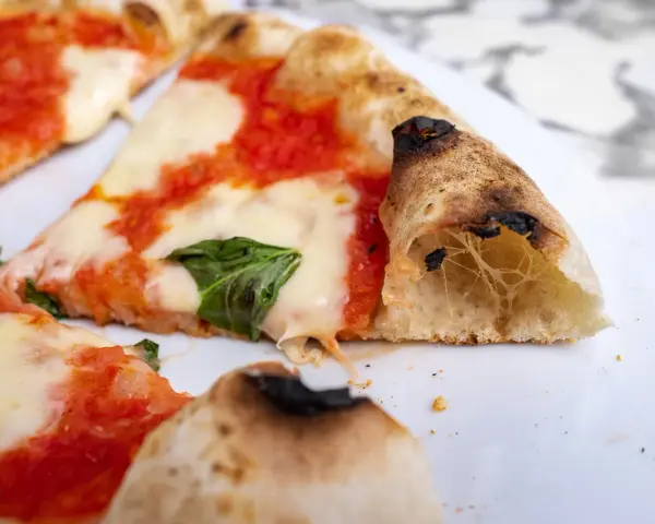 Puszyste ciasto na pizzę neapolitańską z rozpływającym się serem i pomidorowym sosem. Idealne na letni wieczór.