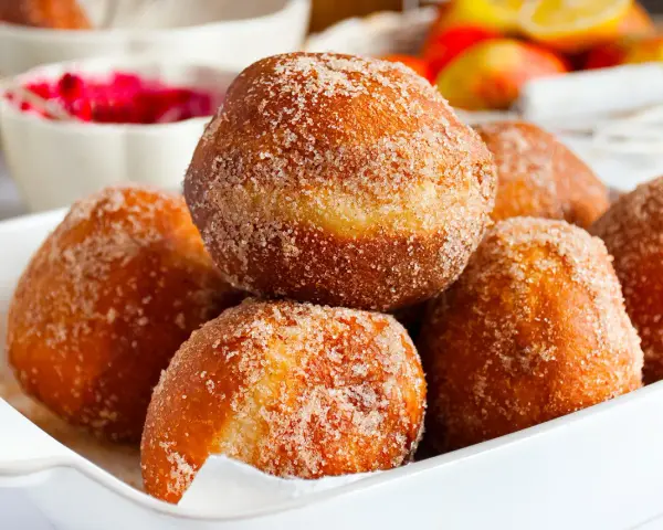 Puszyste pączki posypane cukrem z cynamonem, idealne na tłusty czwartek. Ten przepis na puszyste pączki to gwarancja sukcesu.