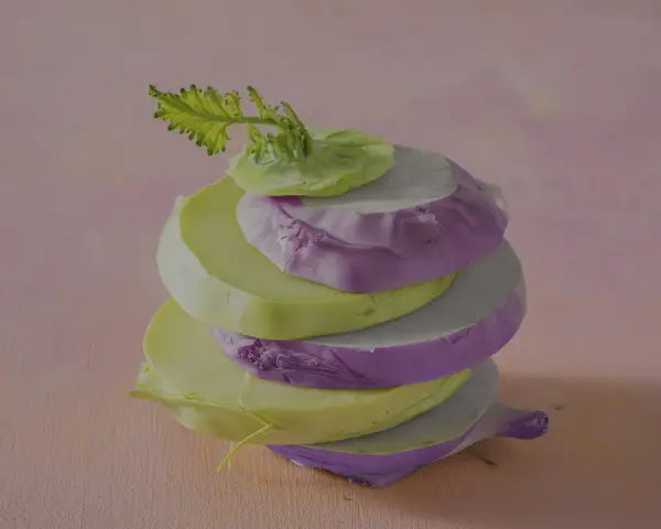 Gestapelte Scheiben von grünem und violettem Kohlrabi, bereit zum Kohlrabi kochen.