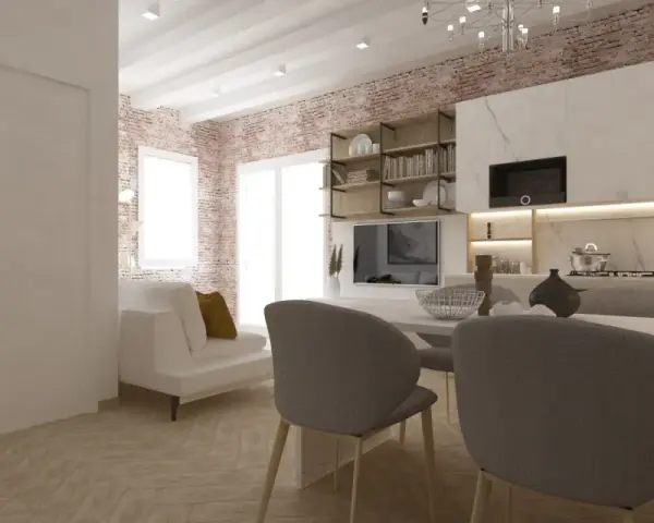 Arredare monolocale con stile: divano bianco, cucina moderna, mattoni a vista e tavolo da pranzo.
