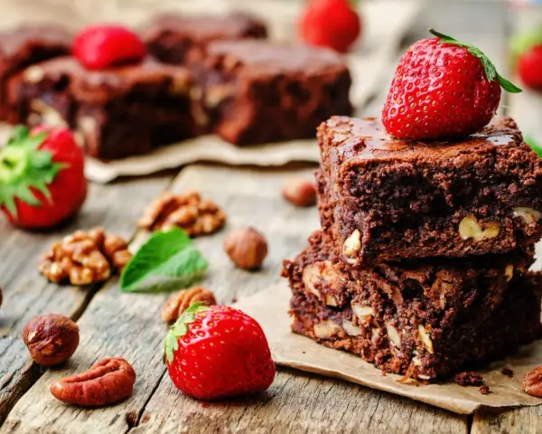 Czekoladowe brownie z orzechami i truskawkami. Pyszna przekąska, której brownie kcal nie zrujnuje diety.