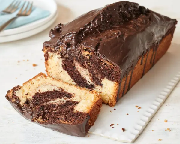 Saftiger Marmorkuchen, frisch aus dem Airfryer, mit Schokoladenglasur und einer angeschnittenen Scheibe.