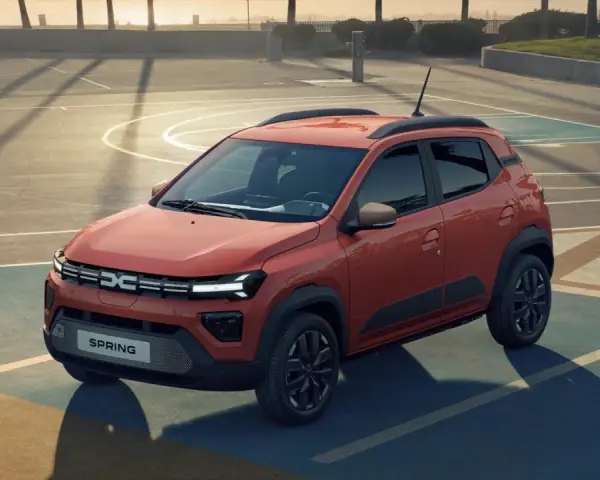 Pomarańczowy Dacia Spring na boisku. Sprawdź atrakcyjną dacia spring cena i odkryj jego możliwości.