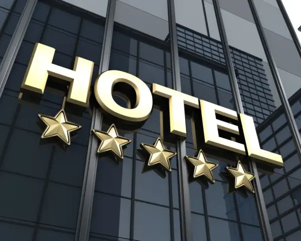 Złoty napis HOTEL i pięć gwiazdek na nowoczesnym budynku. Marzysz, jak zostać testerem hoteli w Polsce?