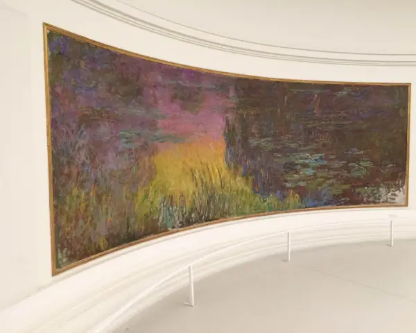 Un estanque de nenúfares con reflejos vibrantes de atardecer, una obra maestra impresionista en el **museo de la Orangerie**.