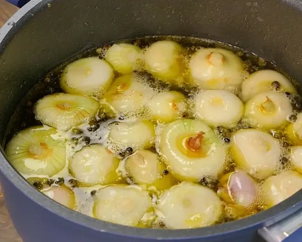 Cipolline in agrodolce in cottura, pronte per essere conservate in barattolo.