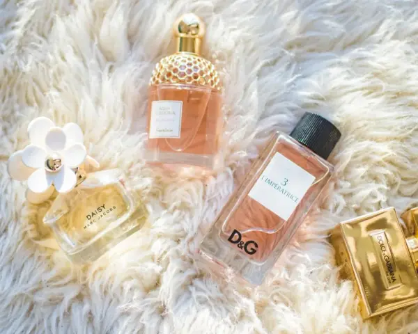 Kolekcja luksusowych perfum damskich: Daisy, Aqua Allegoria, L'Impératrice D&G i The One Dolce & Gabbana na puszystym tle.