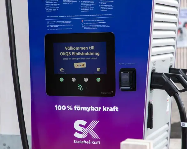 OKQ8 electric car charging station with two charging cables and a screen displaying "Welcome to OKQ8 Electric Charging".