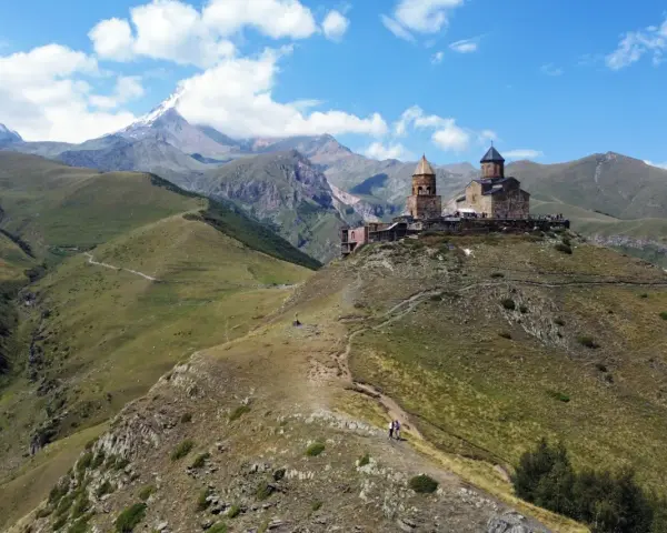 Gruzja wakacje: Kościół Gergeti na tle gór Kaukazu. Widok na malownicze doliny i szczyt Kazbek.