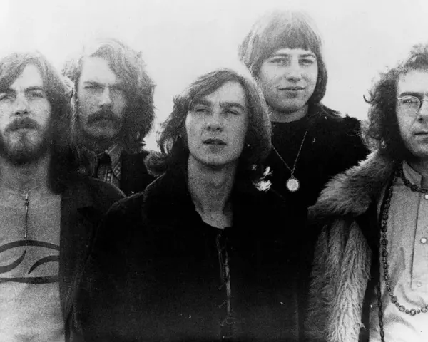 Cinq membres de King Crimson posent ensemble, arborant des coiffures et des vêtements typiques des années 70.