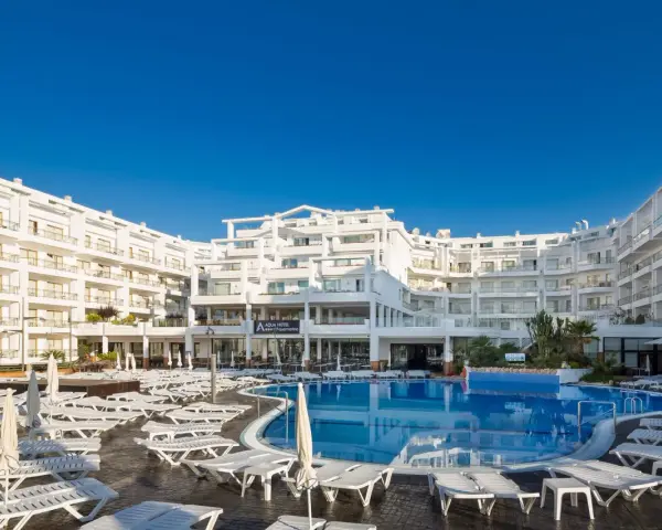 Idealna pogoda na Costa Brava: hotel z basenem i leżakami pod błękitnym niebem.