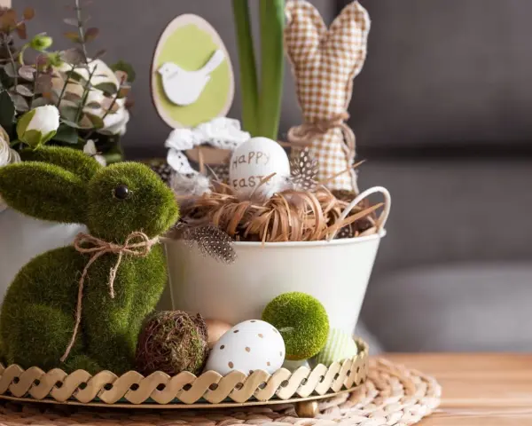 Zielony, mchowy zajączek i pisanki tworzą najpiękniejsze dekoracje wielkanocne. W koszyku jajko z napisem "Happy Easter".