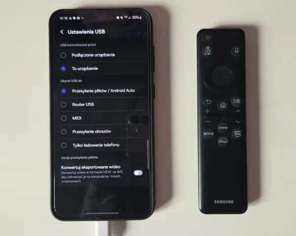 Telefon podłączony do telewizora przez USB. Ustawienia USB na ekranie telefonu pokazują opcje przesyłania plików, co jest kluczowe, jak połączyć telefon z telewizorem.