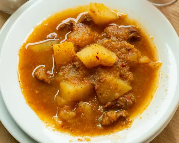 Guiso reconfortante con trozos de carne y patatas en una salsa especiada, perfecto para los alimentos de invierno.