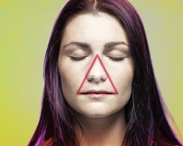 Frauenkopf mit geschlossenen Augen, auf dessen Nase und Mund ein rotes Dreieck liegt. Ein Pickel im Todesdreieck im Gesicht kann gefährlich sein.