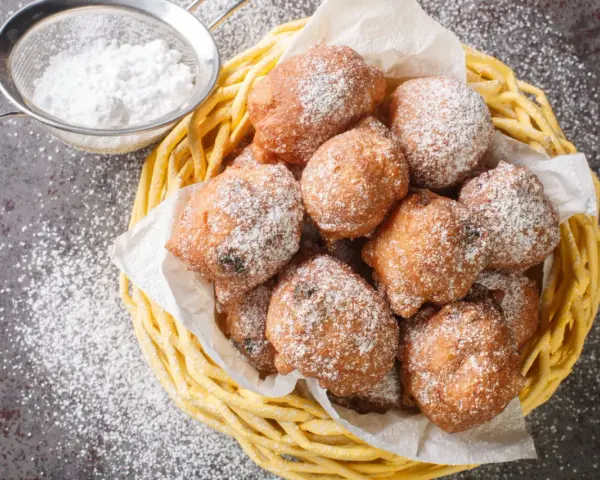 Beignets de carnaval saupoudrés de sucre glace, prêts à déguster. Une recette beignet de carnaval facile et rapide pour le plaisir de tous.