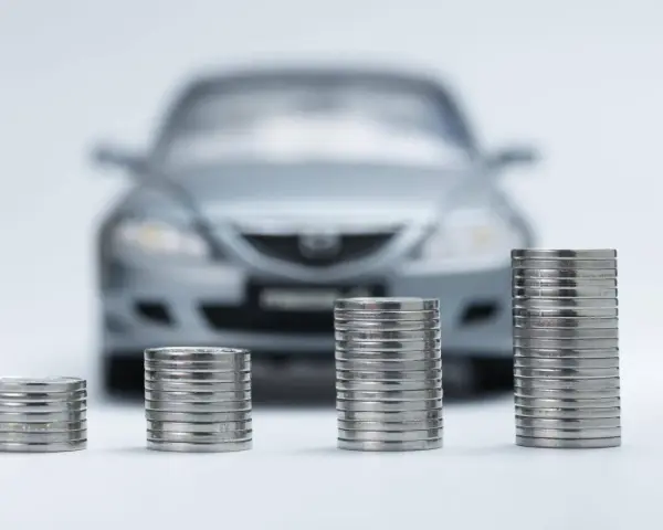 Monete in crescita davanti a un'auto sfocata, simbolo di speranza per l'abolizione superbollo e un futuro più sereno per gli automobilisti.