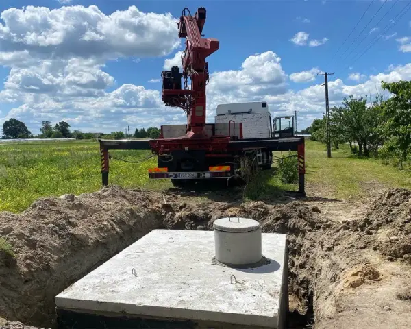 Montaż szamba betonowego w wykopie. Dostępne różne rodzaje szamb, ten jest w trakcie instalacji.