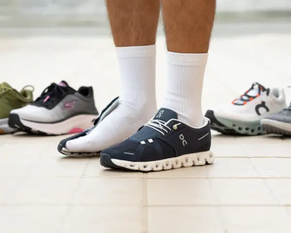 Un hombre prueba varios modelos de zapatillas, buscando el mejor calzado para caminar.