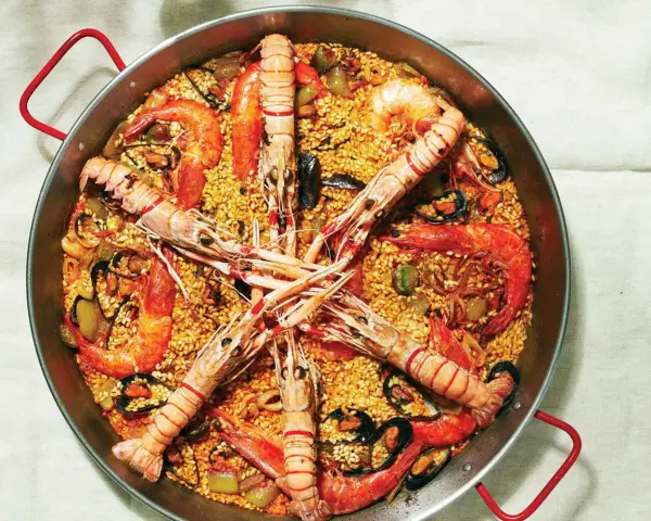Pyszna paella z owocami morza, ryżem i warzywami. Idealny przepis na paellę dla każdego smakosza.
