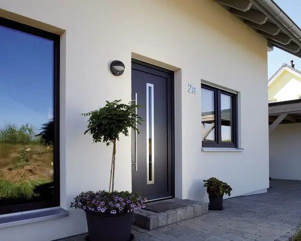 Piante e fiori per abbellire ingresso esterno casa. Porta moderna con maniglia lunga, finestre e numero civico 28.