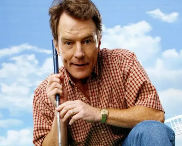 Bryan Cranston w kratę, z kijem golfowym, przypomina postać z jego filmów i seriali.