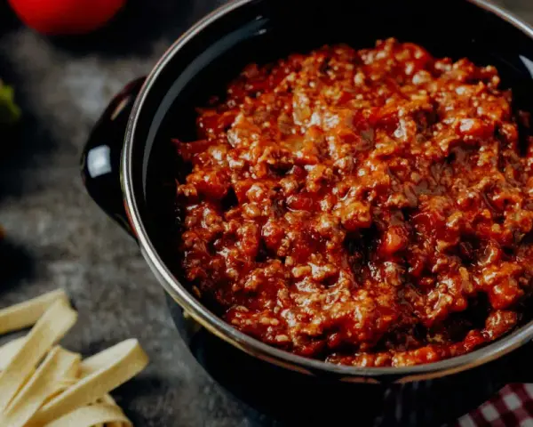 Herzhafte bolognese italienisch Soße in einem Topf, dane frische Pasta, Karotte und Sellerie.