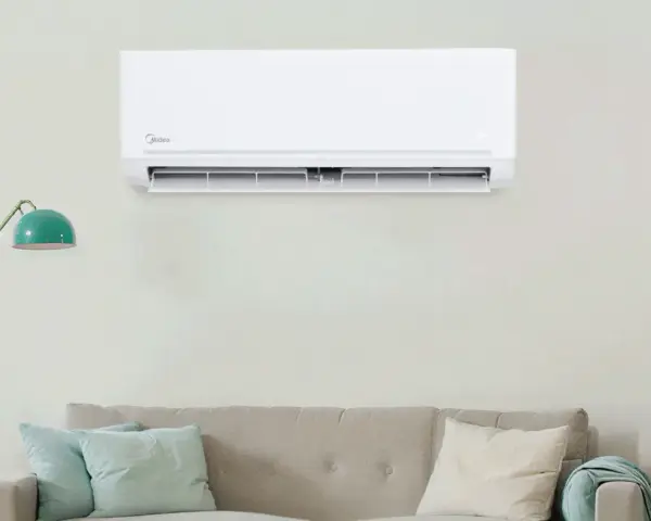 Un aire acondicionado Midea instalado en una pared sobre un sofá. Guía visual para como instalar un aire acondicionado.