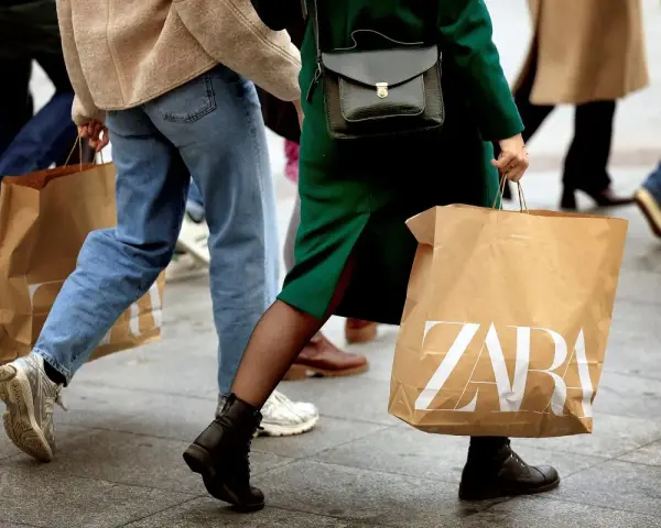 Ludzie idący z torbami ZARA. Może to zakupy, a może zwroty.