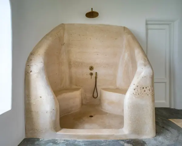 Douche à l'italienne en résine sculptée, avec bancs intégrés. Un inconvénient : le nettoyage peut être délicat.