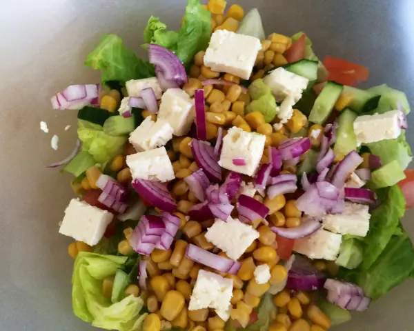 En fräsch sallad med sallad, majs, fetaost, rödlök och gurka. Perfekt för ett lätt och näringsrikt deffa kostschema.