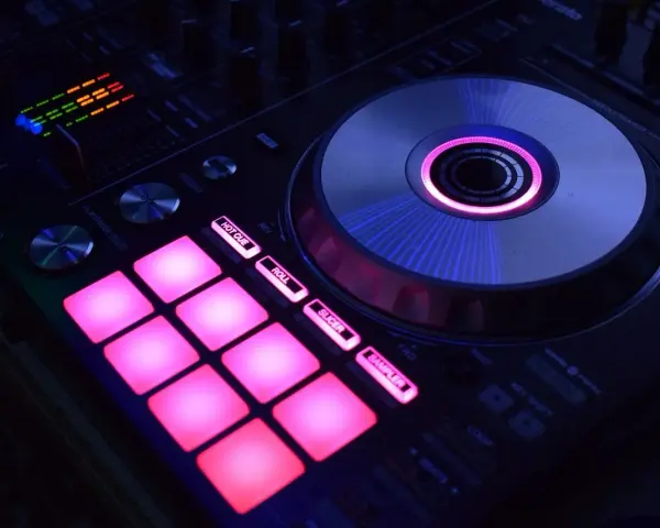 DJ kontroler z podświetlanymi na różowo padami i świecącym na niebiesko talerzem. Idealny do tworzenia muzyki, np. dubstep co to za gatunek?