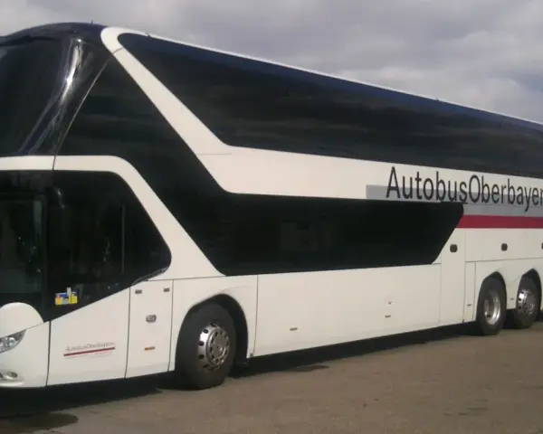 Biały autokar piętrowy z czarnymi oknami i napisem "AutobusOberbayern".