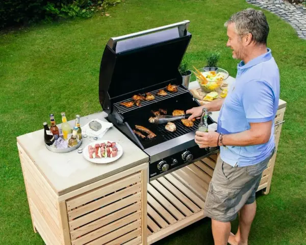 Man grillar på ett fint grillbord i trä. Perfekt för att bygga ett eget grillbord för sommarens fester.
