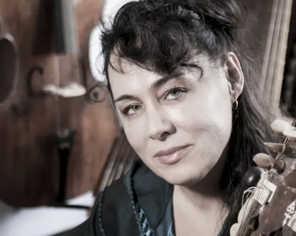 Maria Pomianowska z fidelą i instrumentami smyczkowymi w tle.