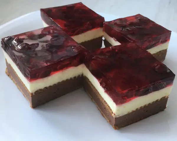 Proste ciasto z serkiem mascarpone i galaretką wiśniową, ułożone na białym talerzu.