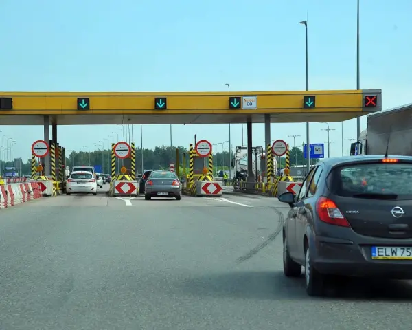 Bramki autostrady A1 z samochodami zbliżającymi się do punktu poboru opłat.